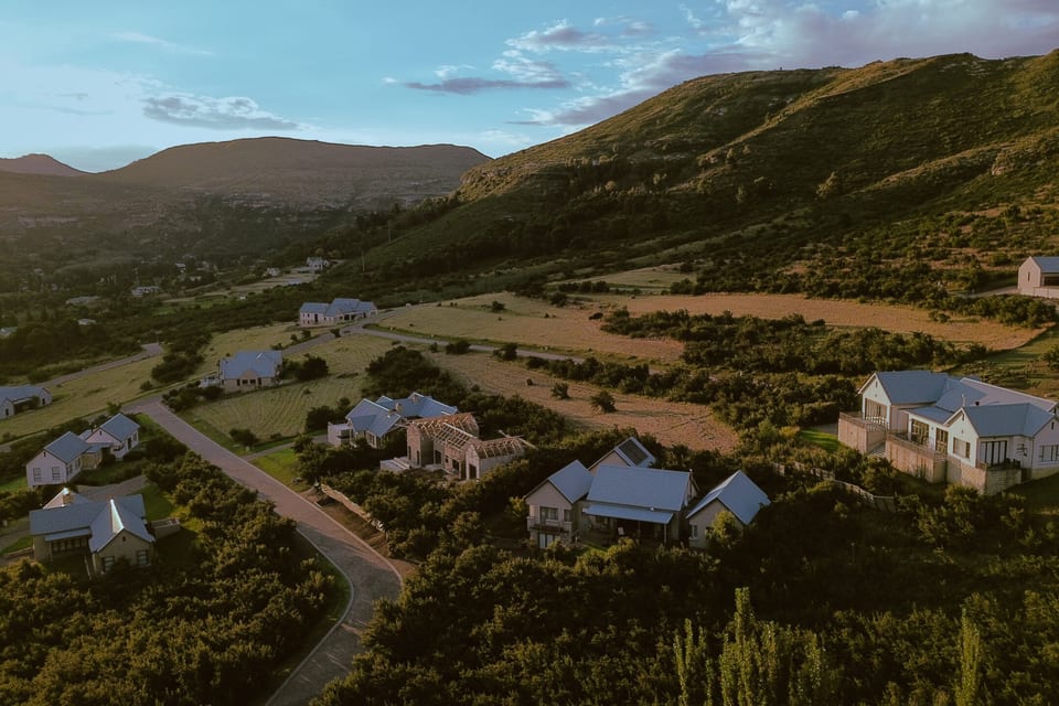 Estate homes set among green belts, with the mountain ridge rising behind